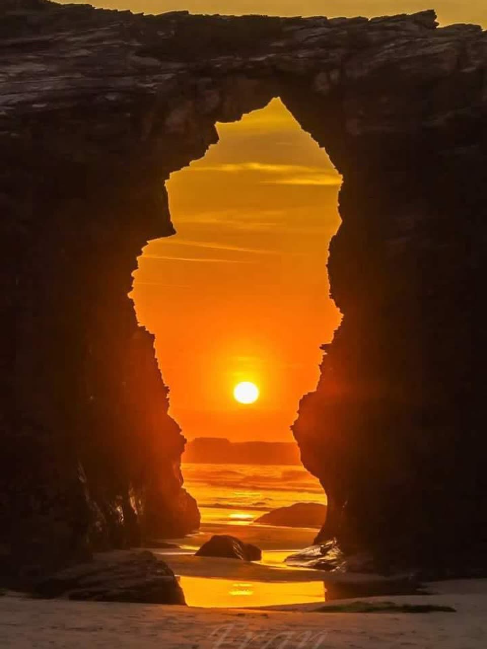 Arco de piedra recortado contra el sol del atardecer
