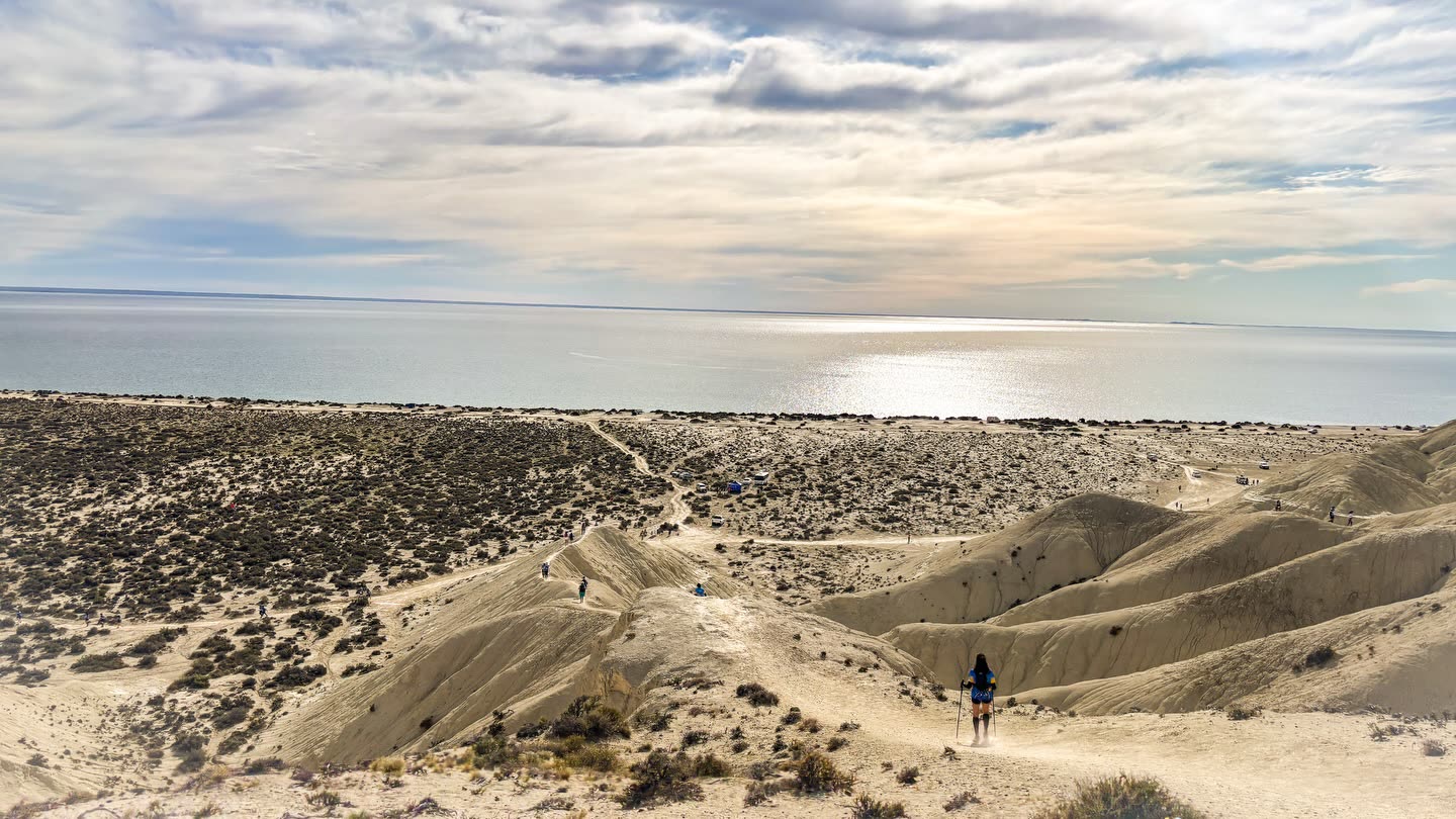 Dunas de arena con una persona caminando a lo lejos