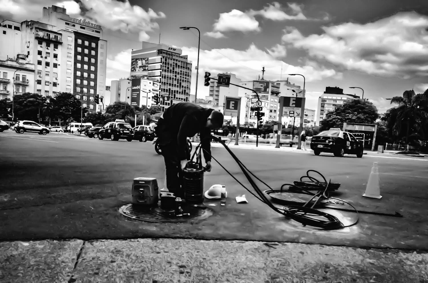 Trabajador con herramientas en una plaza, fotografía en blanco y negro