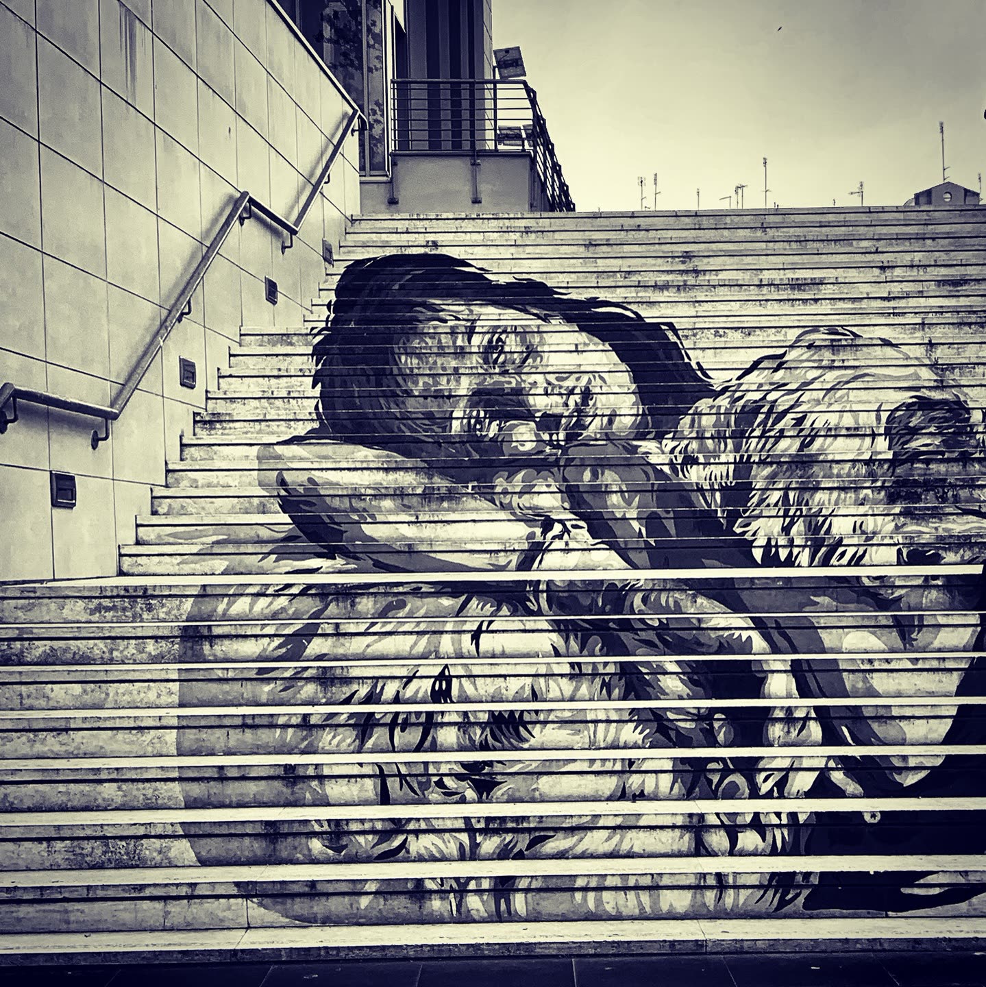 Escalinata pintada con un mural de arte urbano, blanco y negro