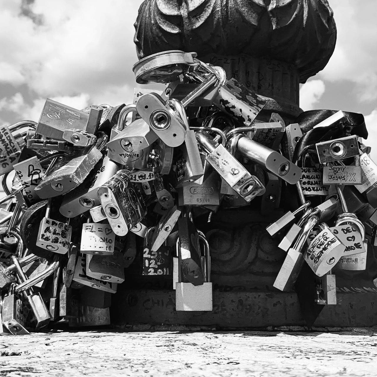Cúmulo de candados sobre una baranda, fotografía en blanco y negro